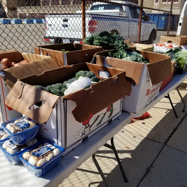 Boxes for fresh vegetables at a farm stand event outside Belmont Charter School